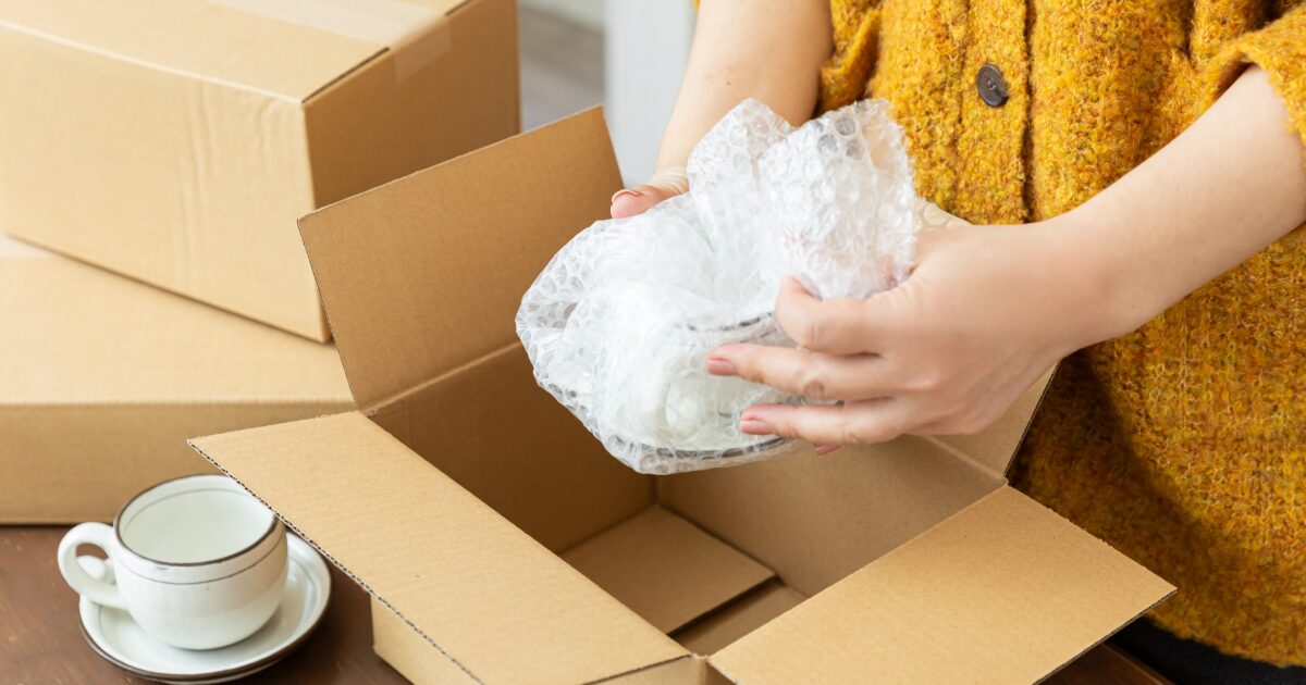 梱包作業中の食器と段ボール箱