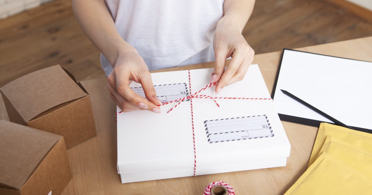 配送用の箱にリボンをかける梱包作業