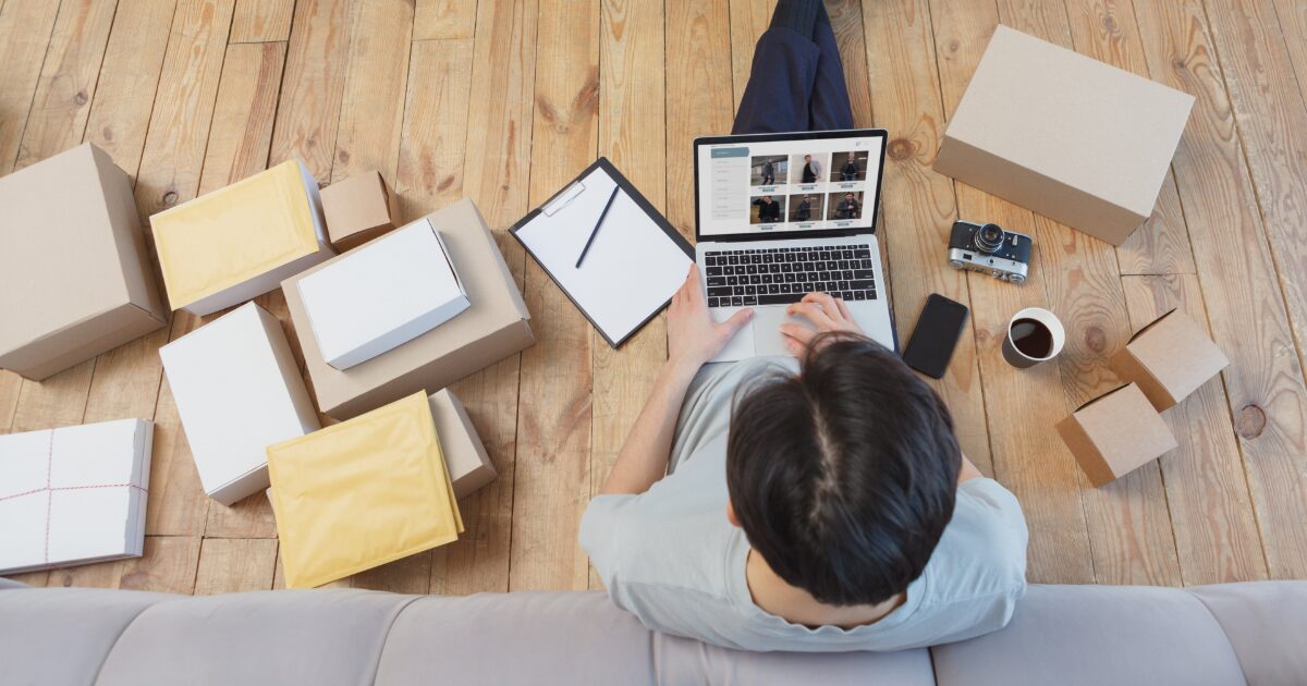 段ボールとノートパソコンでフリマ出品作業をする様子