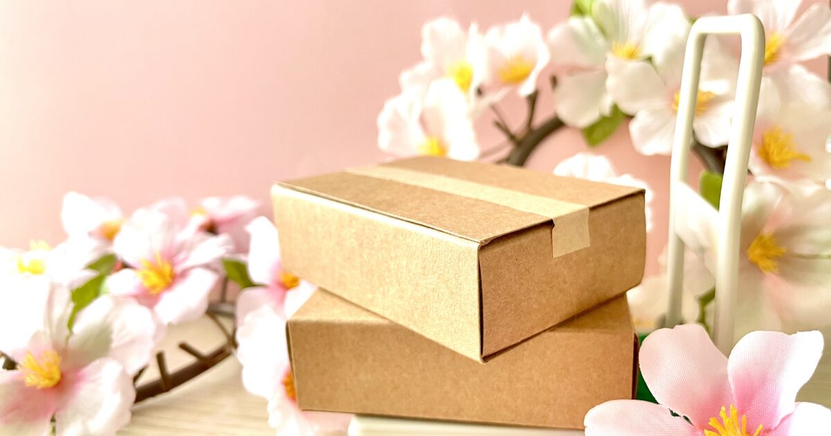 桜の装飾と段ボール小包の春らしいイメージ