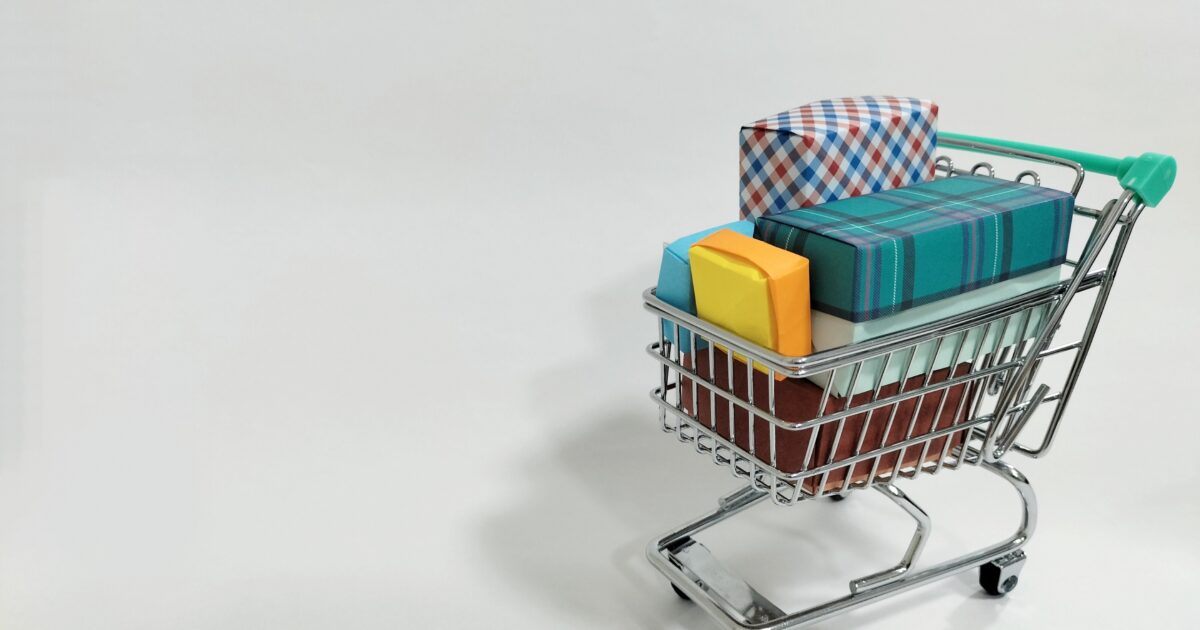 ミニカートにカラフルなギフトボックスを載せたショッピングイメージ